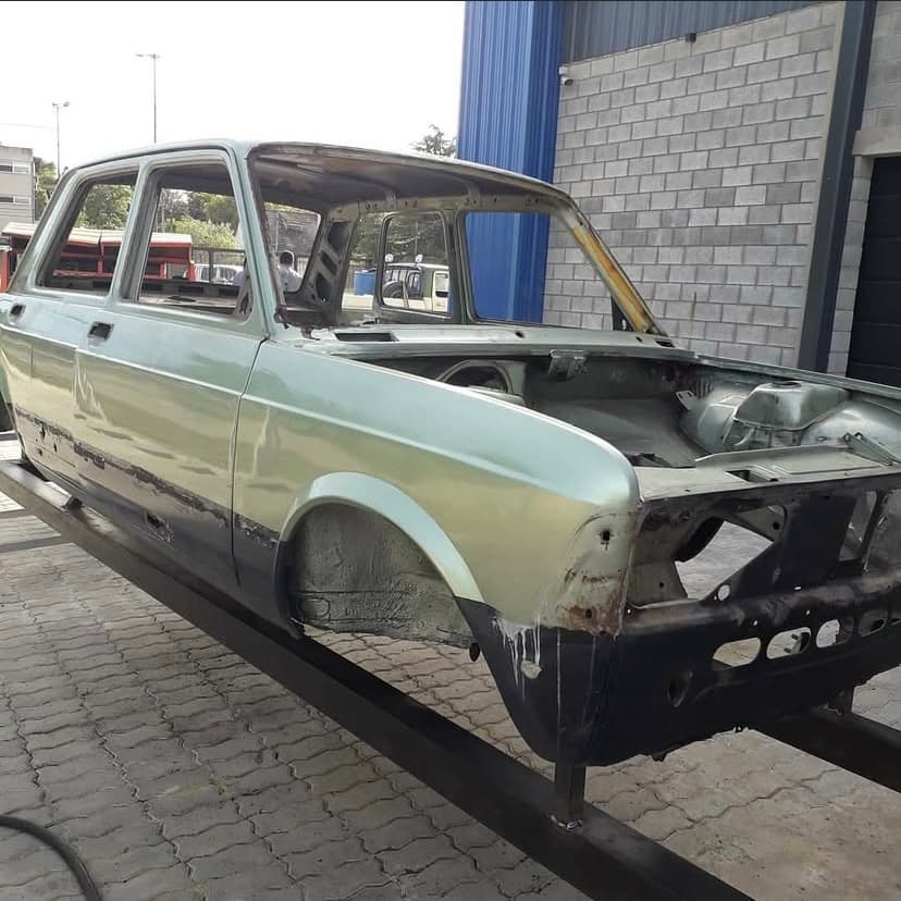 Carrocería de un auto con pintura vieja y óxido en la parte baja, antes de arenar